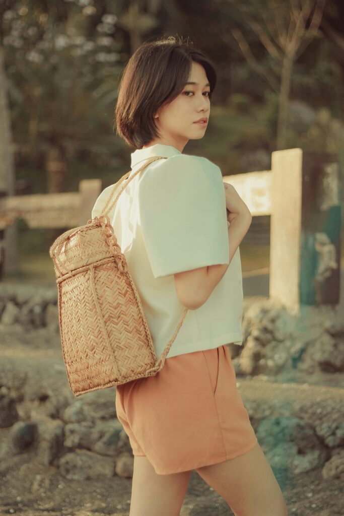 pexels photo 9320729 9320729 Asian woman enjoying a sunny day outdoors with a stylish woven backpack.
